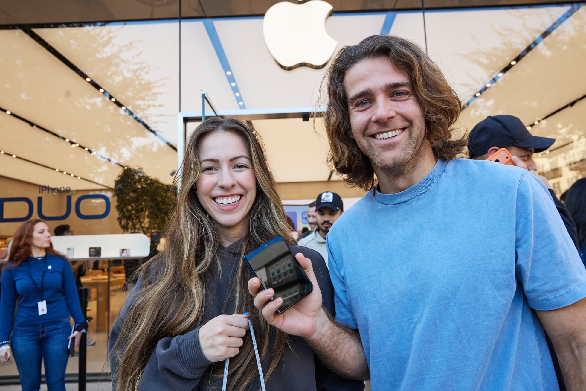 Two customers hold a folded iPhone Duo at Apple Domain NORTHSIDE in Austin during its October23 launch, in Apple’s original launch-day photograph.